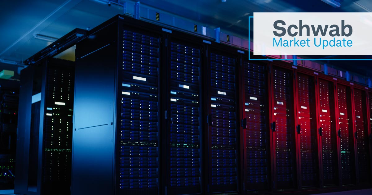 Schwab Market Update: Photograph of data center with multiple rows of server racks illuminated with red and blue lights. 