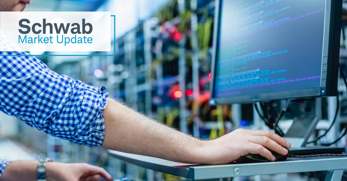 Schwab Market Update: An IT specialist looks at a terminal in a data center.