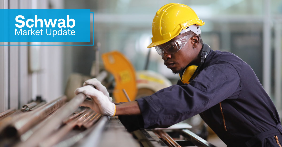 Schwab Market Update: A worker in a hardhat handling metal.