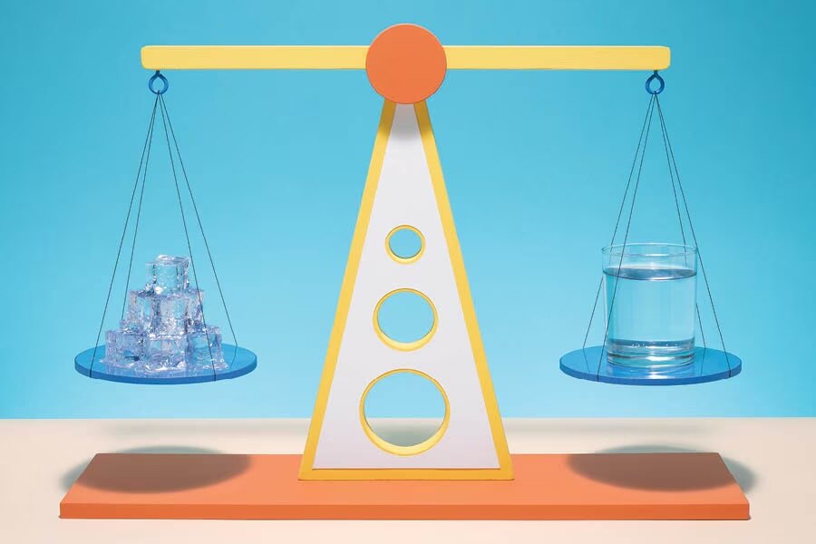 scale with ice on one side and a glass of water on the other.