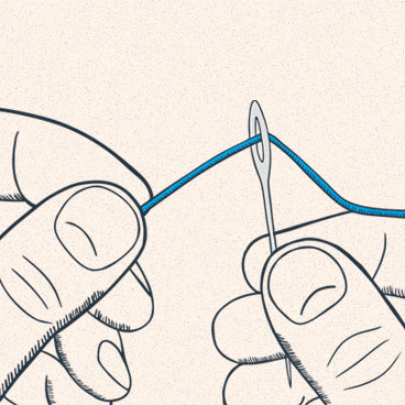 An image showing a person threading a needle. 