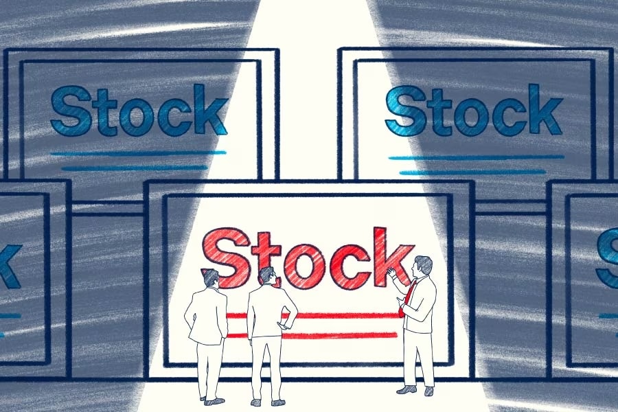 Three people looking at five large stock certificates, one of which is red.